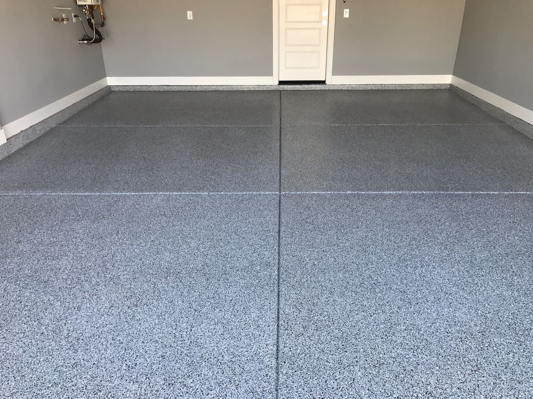 Modern garage with gray epoxy flooring and clean, spacious layout. Ideal for storage and organization.