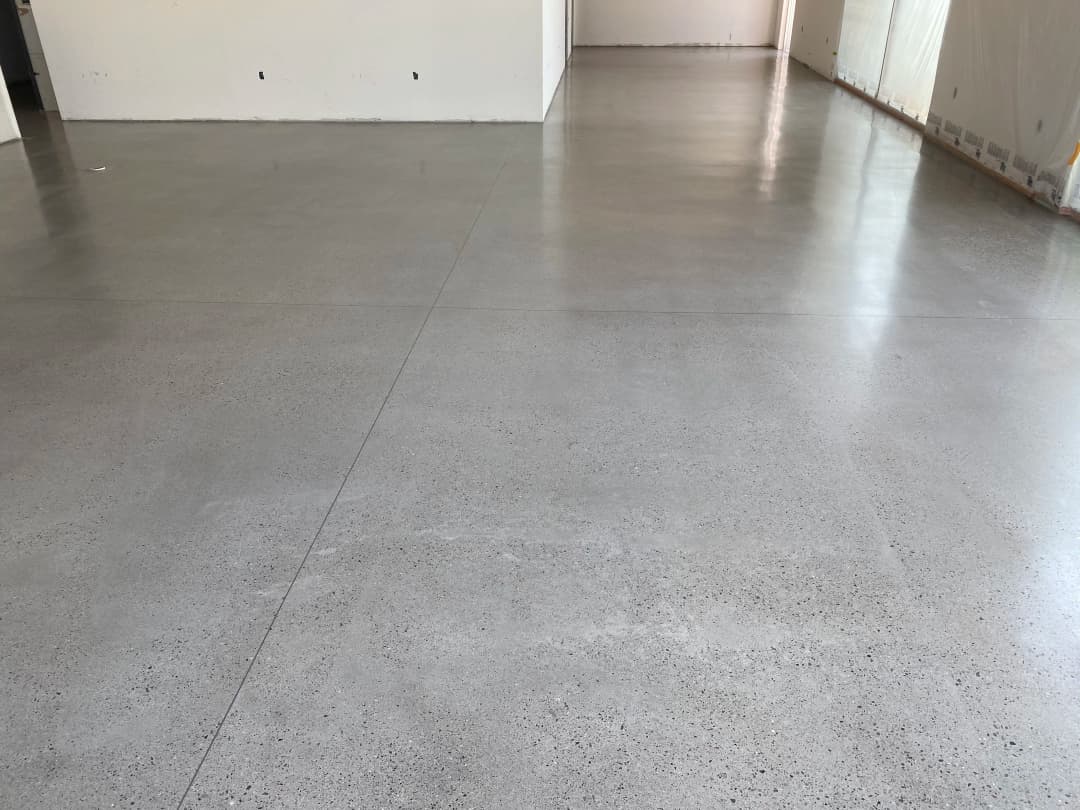 Polished concrete floor in an unfinished interior space, showcasing smooth, modern design.