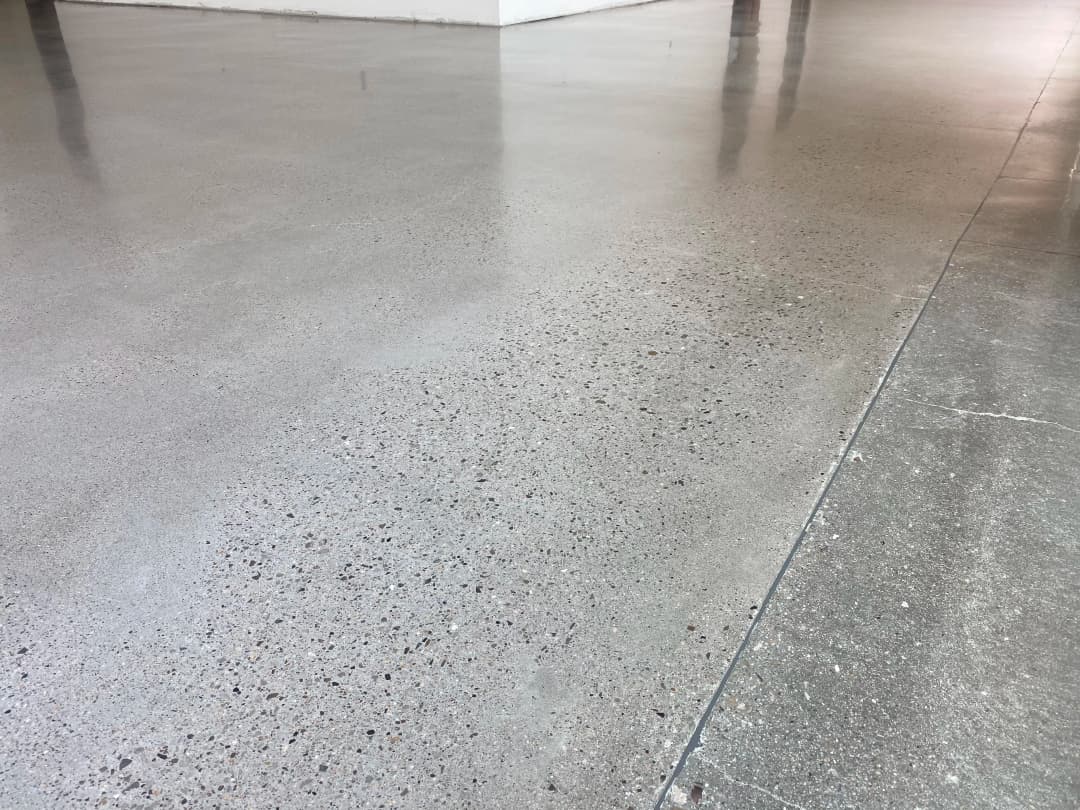 Polished concrete floor with a smooth, shiny finish and subtle texture in a modern interior.