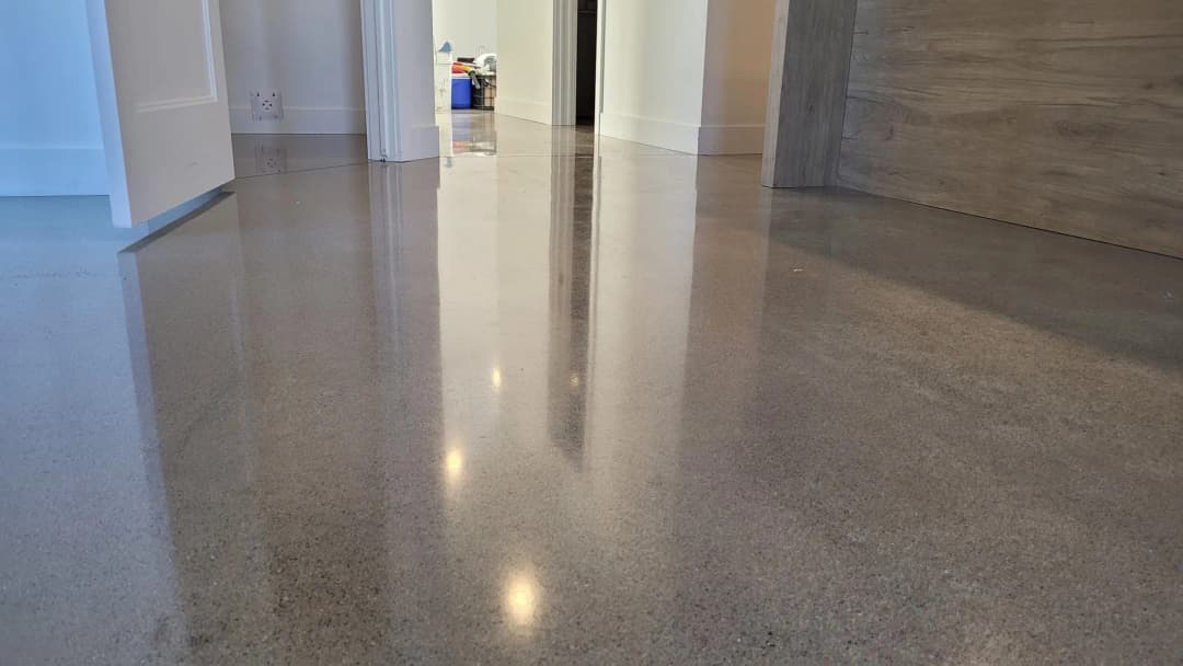 Polished concrete flooring reflecting light in a modern interior hallway.