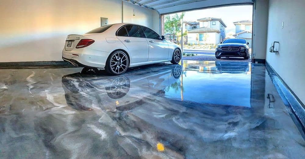 Luxury cars parked in a modern garage with a glossy floor finish and bright lighting.