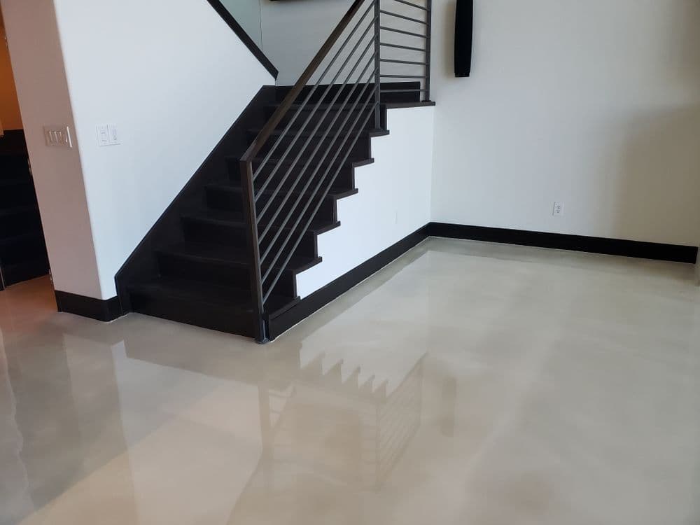 Modern interior with polished concrete flooring, contemporary staircase, and minimalist design.