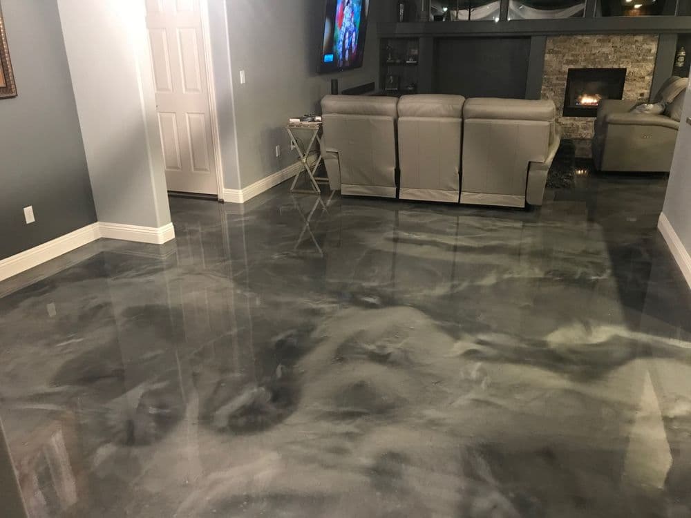 Modern living room with glossy gray epoxy floor and contemporary furniture. Cozy atmosphere.