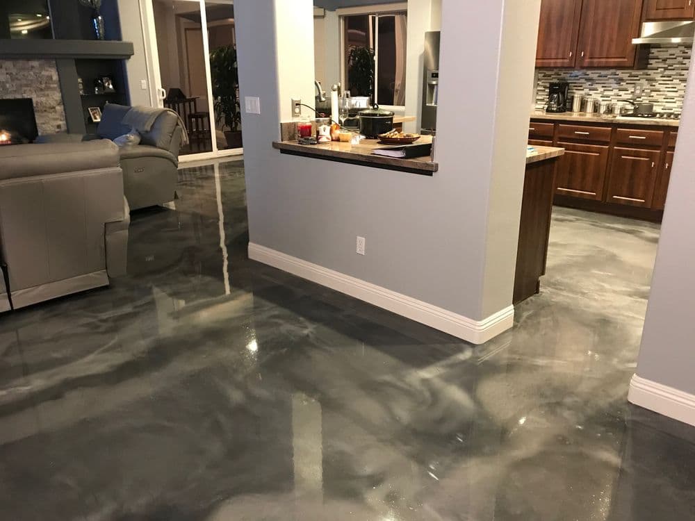 Modern living room with polished gray epoxy flooring and open kitchen design.