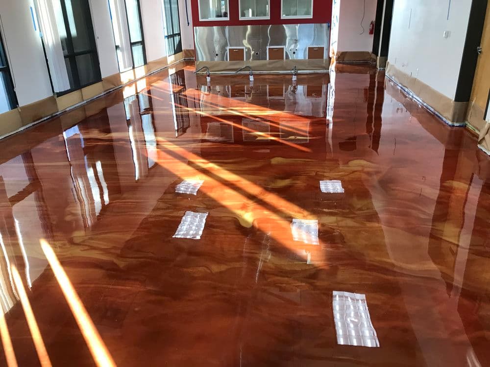 Glossy polished epoxy floor with rich color and reflections in a bright room.