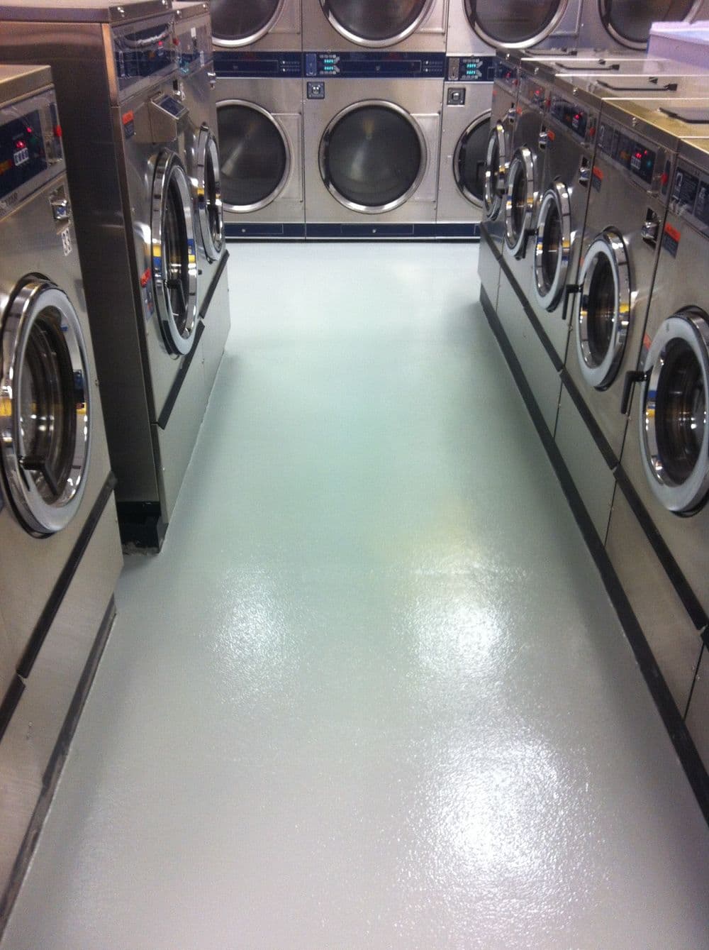 modern laundromat with stainless steel washers and clean, polished floor