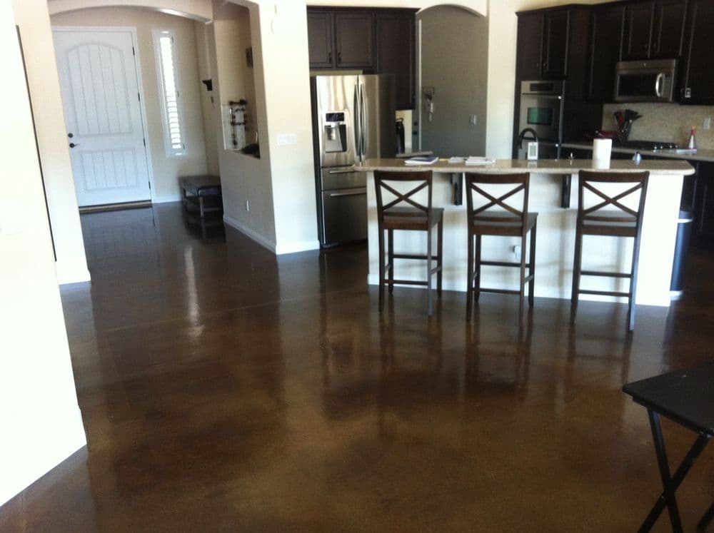 Modern kitchen with polished concrete floors and bar seating in a spacious open layout.