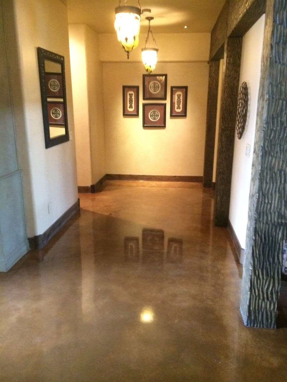 Elegant hallway with polished concrete floor, decorative wall art, and unique lighting fixtures.