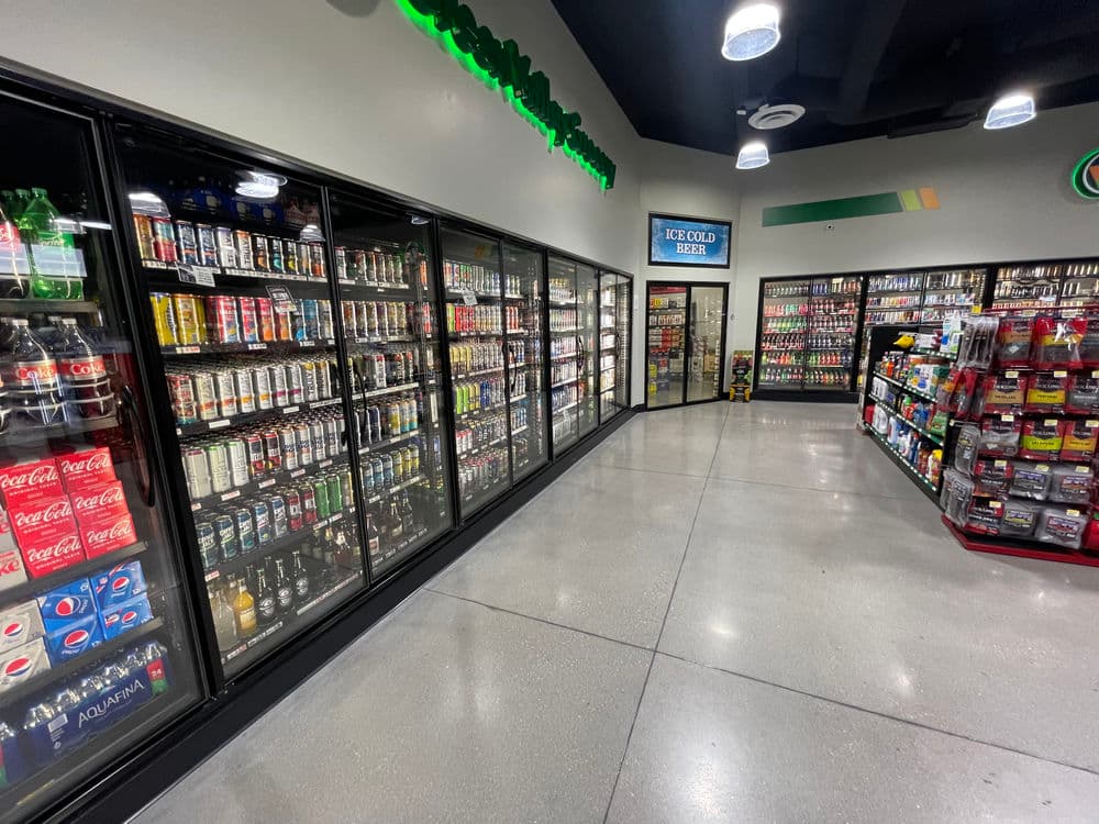 Beverage aisle showcasing various drinks in coolers at a convenience store.