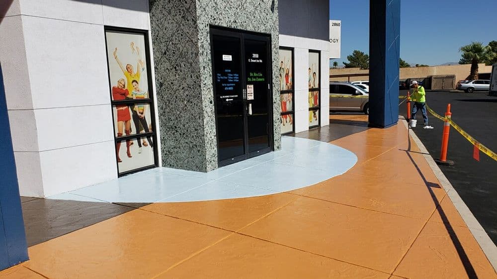 Exterior entrance of a building with colorful athlete murals and freshly painted walkway.