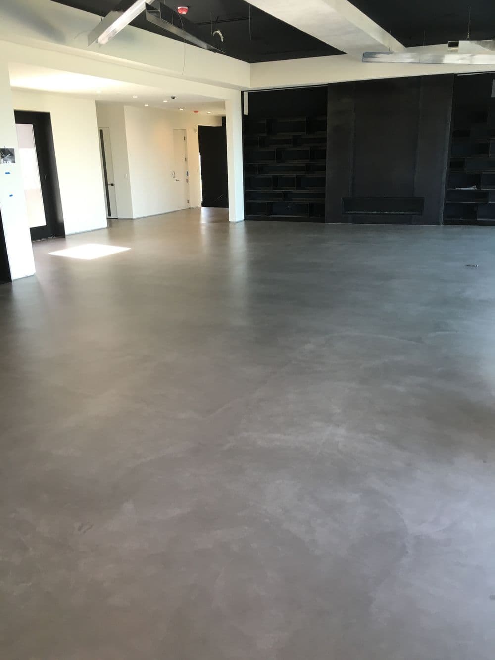 Spacious contemporary room with polished concrete floor and minimalistic design.