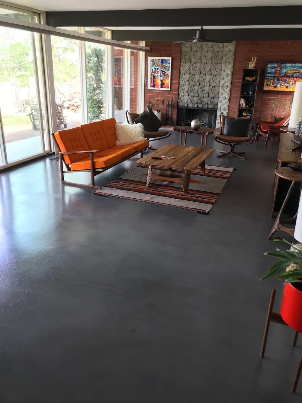 Modern living room with orange sofa, wooden coffee table, and large windows for natural light.