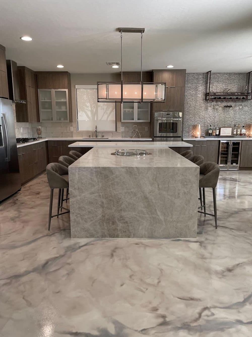 Modern kitchen featuring a large marble island, sleek cabinetry, and stylish pendant lighting.