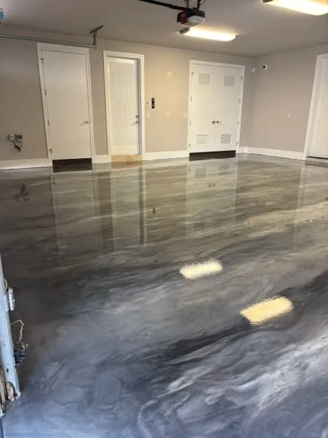 Glossy gray metallic epoxy flooring in a clean, well-lit garage interior.