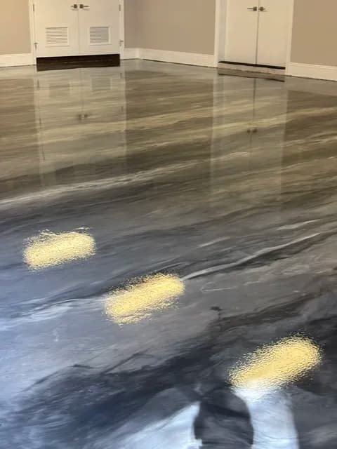Glossy gray and black marbled floor with ceiling lights reflecting in a spacious interior.